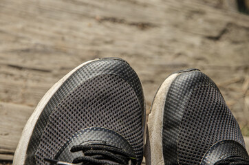 
black sports shoes on the background of a wooden bridge