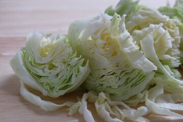 A pile of sliced ​​cabbage on a wooden cutting board