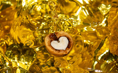 walnut in gold with a heart on a yellow background for design
