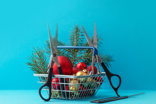Christmas composition. Hairdressing scissors and a spruce branch in a basket with Christmas decorations on a blue background. Template for a postcard or information about a hair salon. copy space.