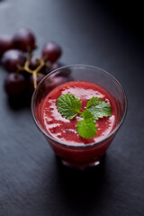 Fresh smoothie in a glass. Dark background. Close up. 