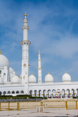 Fototapeta na wymiar White Minaret of Grand Mosque against blue sky, also called Sheikh Zayed BinSultan Nahyan Mosque, inspired by Persian, Mughal and Moorish mosque architecture, in Abu Dhabi, UAE
