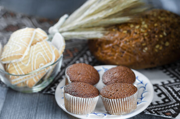 Delicious cupcakes on a blurry rustic background with cookies and bread. Soft selective focus