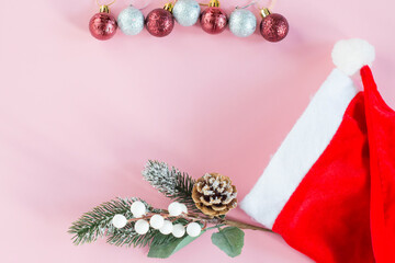 Christmas decorations from Santa Claus hat on pink background.