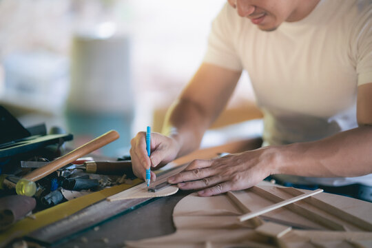 craft man making guitar on wood table, capenter working concept