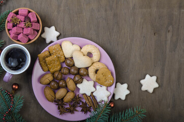Obraz na płótnie Canvas Cookies in a saucer, sugar in a wooden bowl, a cup of coffee and fir branches.