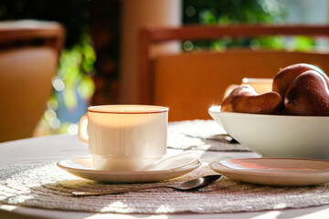 Cup of coffee and croissants on table in coffee shop. Selective focus