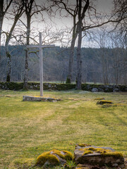 Obraz premium Wooden cross dominates the scene in a country cemetery