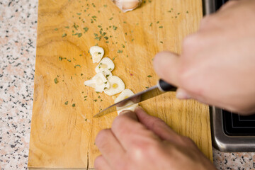 Man cutting garlic with a knife