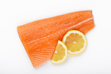 Fresh raw salmon fillets with herbs and lemon isolated on white background.