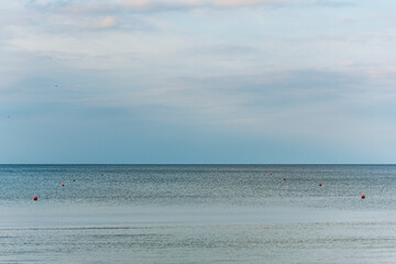 calm water surface on which orange buoys fly