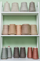 Pile of big colorful spools of yarn on shelving