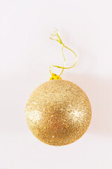 Christmas toy for the Christmas tree and new year. Beautiful gold ball isolated on the white background