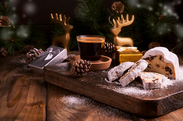 Traditional German sweet bread with dried fruits and marzipan for Christmas. Stollen and aromatic espresso coffee with gift boxes on a wooden background. Copy space. High quality photo.