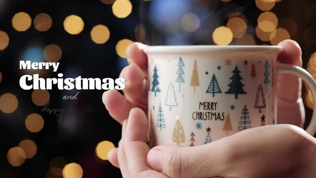 Christmas concept. Female hands hold white mug with hot drink from which steam is coming, Merry Christmas and happy New Year text coming up on left side of image