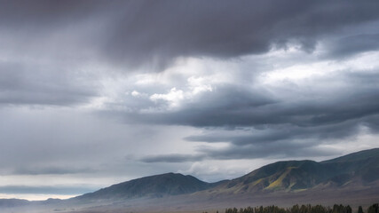 Fototapeta premium sky with evening clouds over mountain ridge in fall