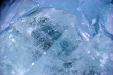 Naklejka na ściany i meble Blue blocks of ice close up with bubbles and cracks