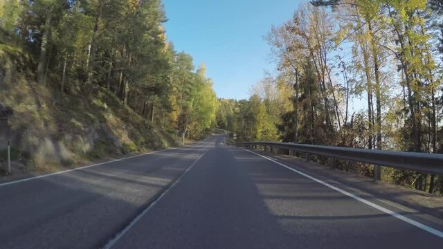 Autumn road in forest. Drive along shore of the Ladoga lake.  POV.