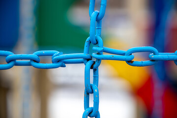 Crossed blue metal chain on blurred background