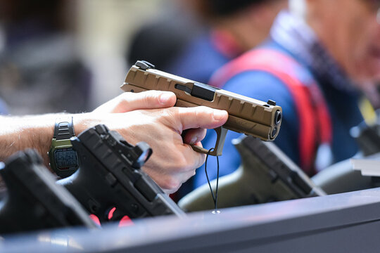 Vicenza, Italy - February 8, 2020:  A man tries the Beretta APX, a striker-fired semi-automatic pistol,  on display at Hit Show 2020, trade fair show dedicated to hunting, target sports and outdoor