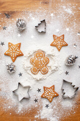 Traditional Christmas gingerbread cookies lying on a floured kitchen table