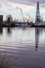 Obraz premium Cranes and ships at dawn near the shore in the port