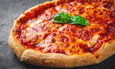 sliced Pizza with Mozzarella cheese, Tomatoes, pepper, Spices. Italian pizza. Pizza Margherita or Margarita on Dark grey black slate background