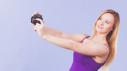 Blonde woman with camera on blue