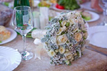 white wedding flowers in Selective focus and blurred background . Close up picture of empty glasses in restaurant . Selective focus . A bouquet of white wedding flowers on the table.