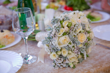 white wedding flowers in Selective focus and blurred background . Close up picture of empty glasses in restaurant . Selective focus . A bouquet of white wedding flowers on the table.