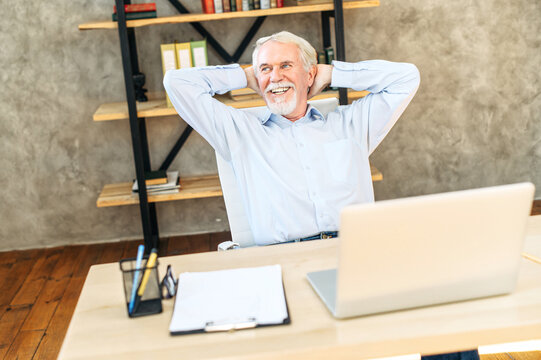 Lucky day. Elderly businessman leaned back in chair in modern office and smiles with satisfaction