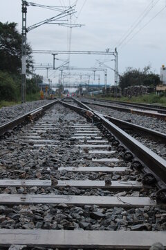 A photo of railway track intersection against a backdrop of a railway station in India.