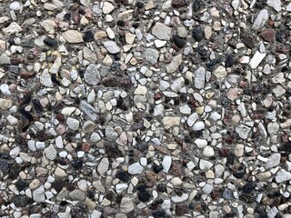 varied color rocks (gravel) in a concrete wall background