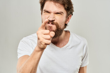 man in white t-shirt emotions expressions gesture with hands cropped view light background