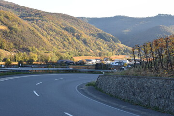 kurvige Straße durch die Weinberge ins herbstlich bunte Ahrtal bei Dernau