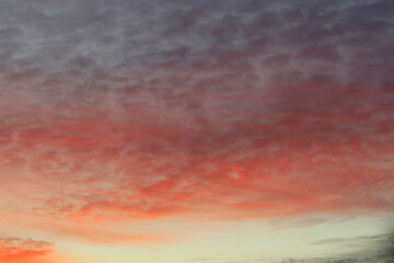 Fototapeta premium Sun below the horizon and clouds in the fiery dramatic orange sky at sunset or dawn backlit by the sun. Place for text and design