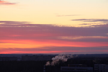 Sun below the horizon and clouds in the fiery dramatic orange sky at sunset or dawn backlit by the sun. Place for text and design