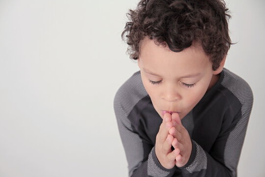 boy praying to god with hands together on white background stock photo
