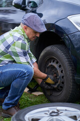 Fototapeta premium Man changing a flat tyre