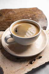 A cup of hot black morning coffee with a vintage marble table. A close up of americano or double espresso. Coffee break.