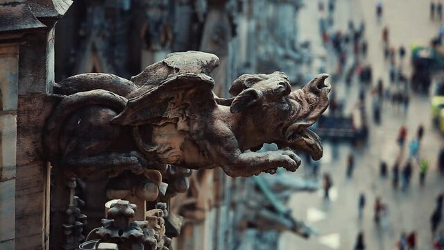 Stone gargoyle on roof top of Duomo di Milano.Scary medieval statue on facade of ancient Italian catholic church in center of Milan city
