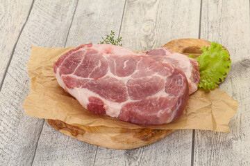 Raw pork steak over wooden board