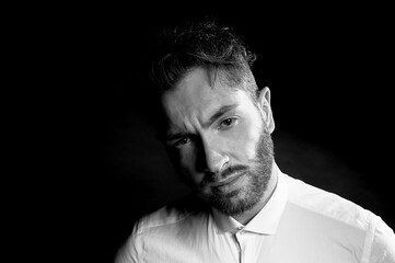 Obraz premium A man on a dark background. With furrowed brows.With thoughts of a difficult future.