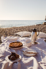Fototapeta na wymiar Beach picnic with cake, figs and tea