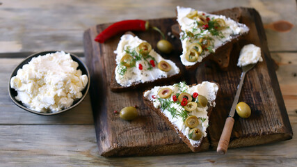 Selective focus. Macro. Mascarpone sandwiches with olives and spices.