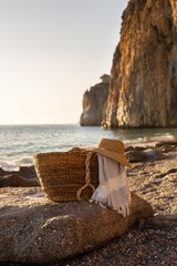 Summer concept. Woven basket with a straw hat and picnic blanket