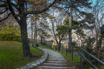 Beautiful park in the castle of the city of Brescia on a sunny clear day against a bright blue sky. Part of Brescia castle. Castello di Brescia, Lombardy, Italy.