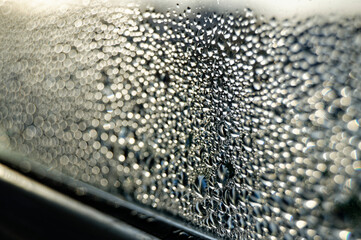 Foggy window in drops during sunset