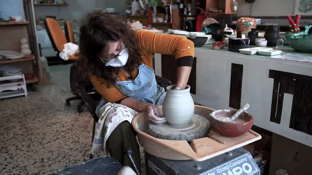 Encantador maestro de alfarer&iacute;a haciendo cer&aacute;mica sobre rueda. Artesan&iacute;a.