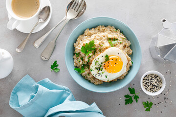 Savoury oatmeal with fried eggs sunny side up for breakfast